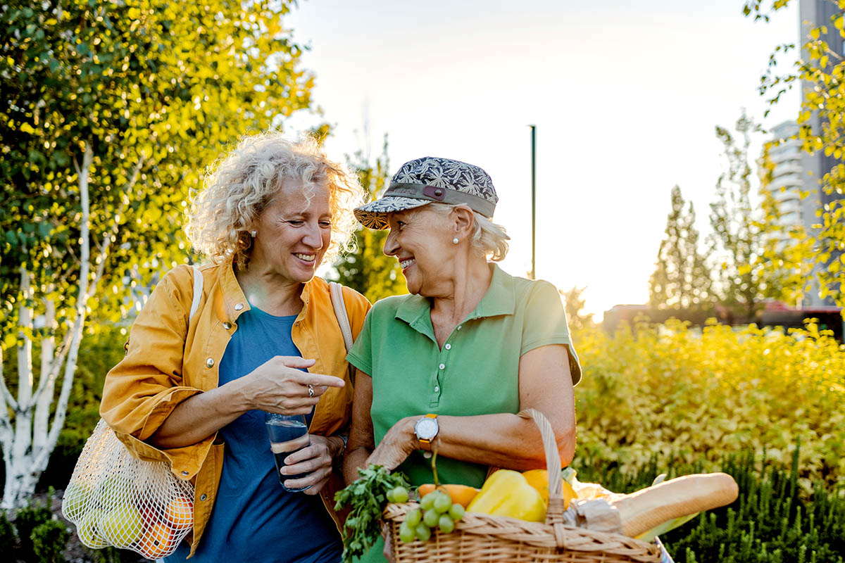 Two older women walking and laughing.